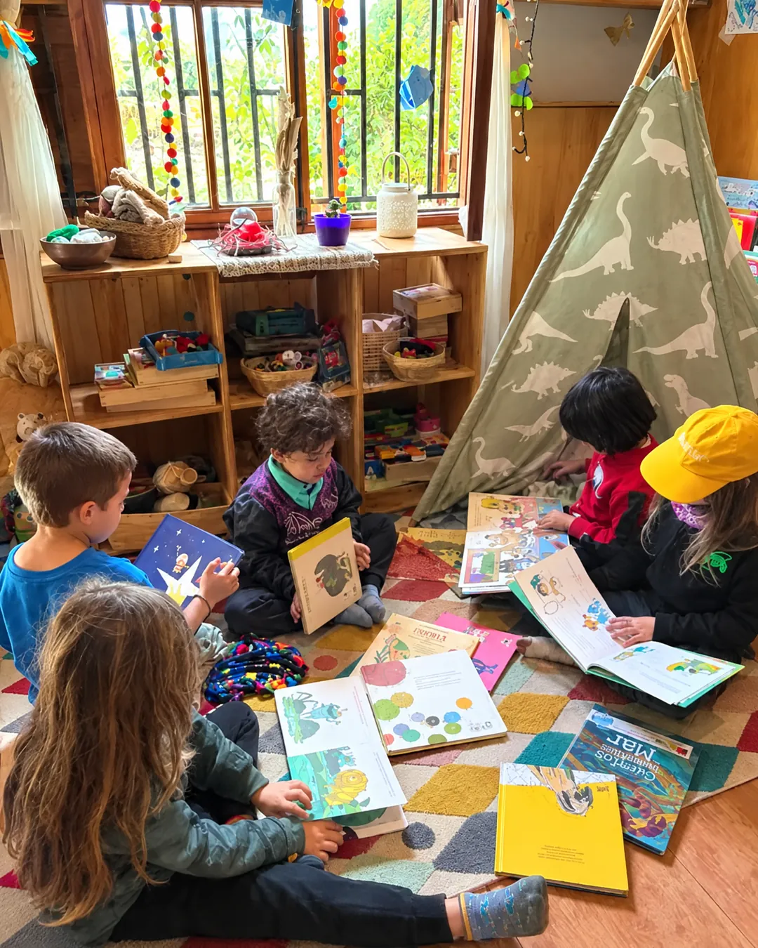 Niñas y niños leyendo libros ilustrados sobre una alfombra